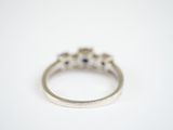 an image of a diamond and sapphire ring on a white surface
