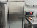 a stainless steel refrigerator in a kitchen with a microwave on the counter
