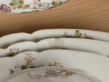 a stack of white plates with floral designs on them