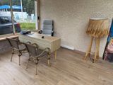 a desk and chairs in a room with a picture on the wall