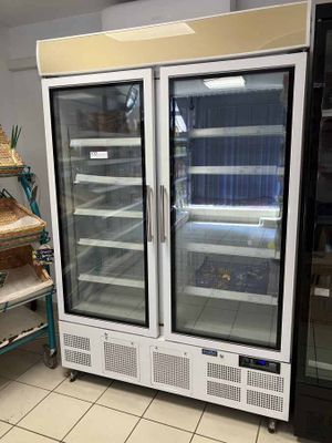 two refrigerators that are sitting in a room