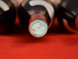several bottles of wine are lined up on a red surface