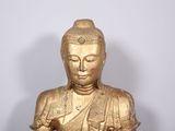 a gold statue of a buddha sitting on a table
