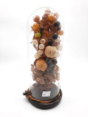 une cloche en verre contenant un bouquet de fruits