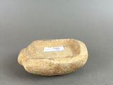 a stone bowl with a label on it sitting on a table