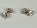 paire de boutons de manchette en argent sertis de diamants sur fond blanc