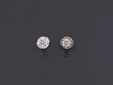 a pair of diamond earrings on a black surface