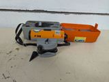 an orange and gray machine sitting on top of a table next to a tool box