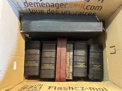 plusieurs livres superposés dans une boîte