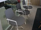 Plusieurs chaises sont alignées en rang dans un bureau.