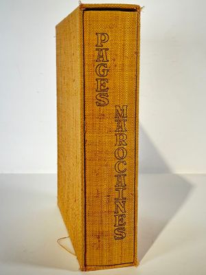 an old book sitting on top of a table next to a white wall