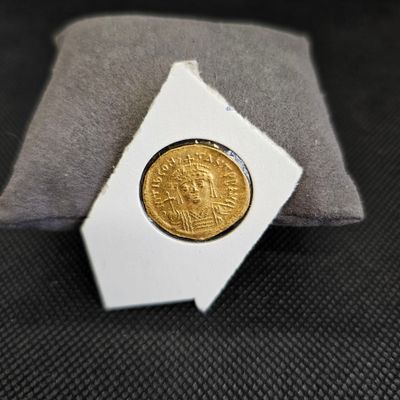 une pièce d'or posée sur un oreiller