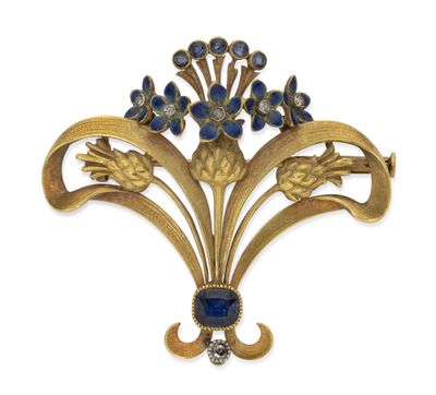a close up of a gold brooch with blue stones