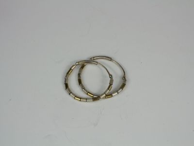 pair of gold tone bamboo bracelets on a white surface