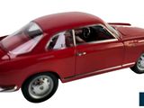 a red toy car that is sitting on a white surface