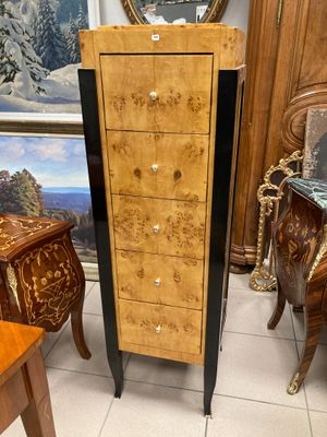a wooden cabinet with drawers and a mirror in the background