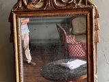 un miroir accroché au mur dans lequel on voit une poupée