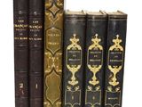 plusieurs vieux livres sont alignés sur une surface blanche