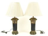 une paire de lampes de table noires et dorées avec des abat-jours blancs