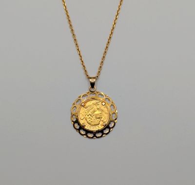 a gold necklace with a coin on a chain