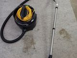 a vacuum that is sitting on the floor next to a hose