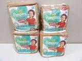 trois boîtes de couches Pampers posées sur une table