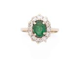 une bague ovale sertie d'une émeraude et d'un ensemble de diamants