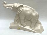 a white elephant statue on a stand on a white surface