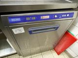 stainless steel dishwasher in a commercial kitchen with a red trash can