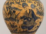 a vase with a painting on it sitting on a table