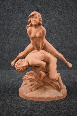 an image of a statue of a woman wrestling a man on a rock