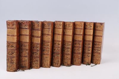 plusieurs vieux livres sont alignés sur une surface blanche