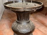 a birdbath sitting on a pedestal in the middle of a room