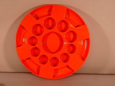 an orange plastic plate with holes in the middle of it