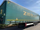une semi-remorque verte garée sur le bord de la route