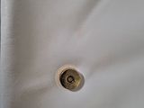 a close up of a button on a white shirt