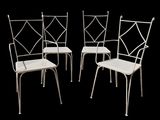 trois chaises en métal blanc placées les unes à côté des autres sur un fond noir