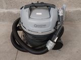 un aspirateur posé par terre près d'un mur