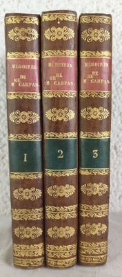 trois vieux livres sont alignés sur une table