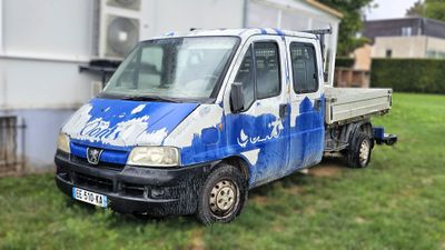 un camion bleu et blanc garé devant une maison