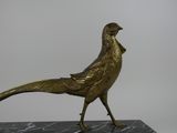 statue of a golden pheasant on a black marble base