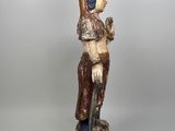 a wooden statue of a woman holding a sword in her hand