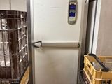 a refrigerator that is next to some baskets on the floor