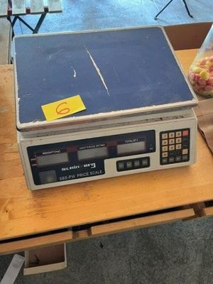une photo d'une balance posée sur une table, à côté d'un sac de pommes