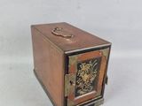 une petite boîte en bois sur laquelle est représentée une horloge