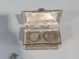 a small silver box with a pair of glasses in it