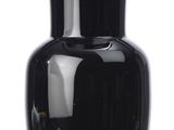 a black vase that is sitting on a white surface