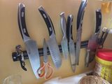 many knives hanging on the wall next to each other