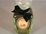 a bottle of perfume with a black bow on it