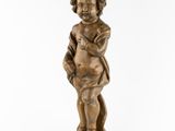 a small wooden statue of a child holding a book